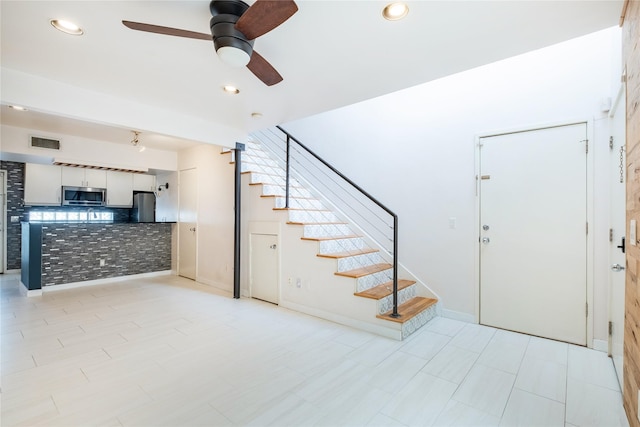 interior space with ceiling fan