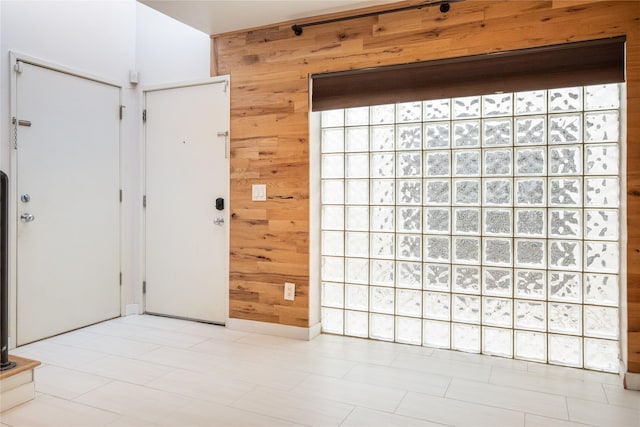 foyer entrance featuring wood walls