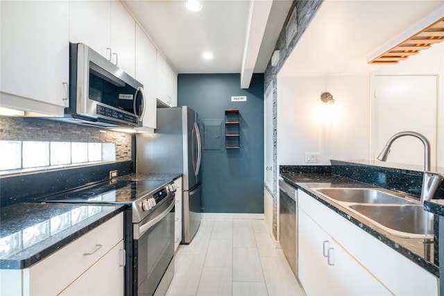 kitchen featuring stainless steel appliances, tasteful backsplash, sink, and white cabinets