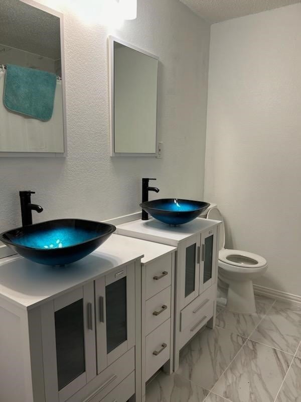 bathroom with vanity, a textured ceiling, and toilet