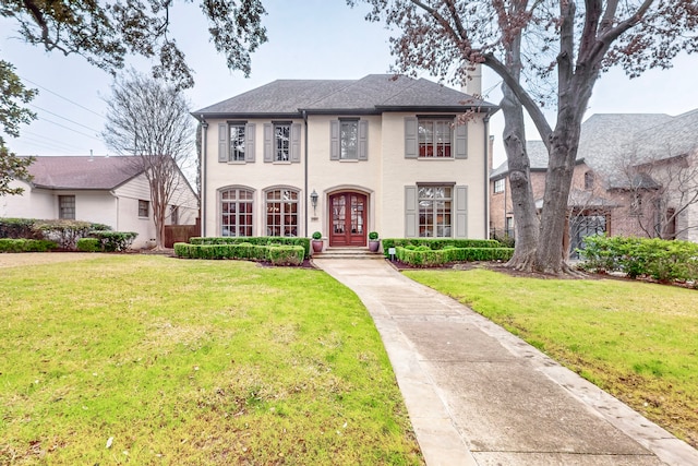 view of front facade with a front lawn and french doors