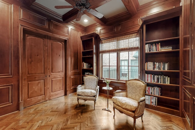 sitting room with coffered ceiling, beam ceiling, light parquet flooring, and wood walls