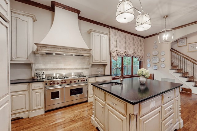 kitchen featuring sink, crown molding, premium range hood, hanging light fixtures, and range with two ovens