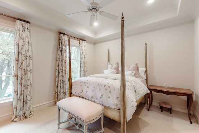 bedroom featuring a raised ceiling, crown molding, carpet, and ceiling fan