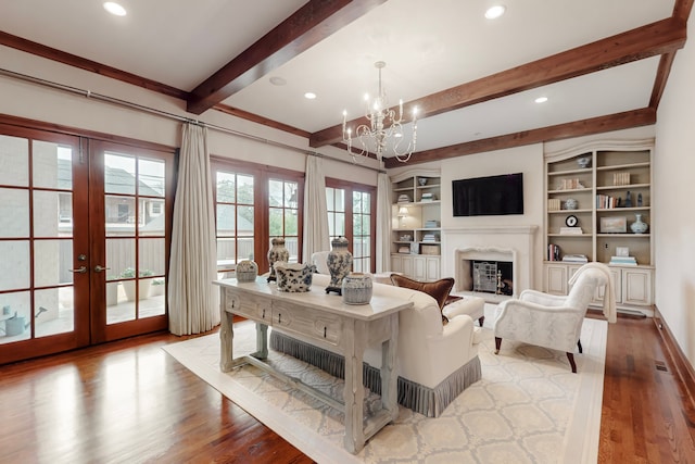 living room featuring a notable chandelier, beam ceiling, wood-type flooring, and french doors