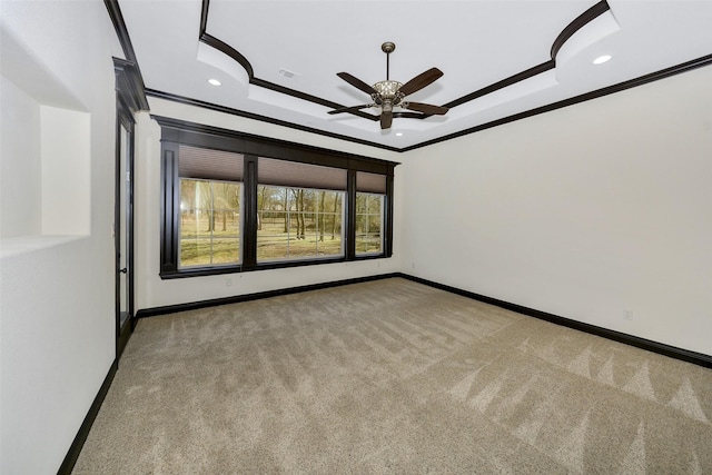 unfurnished room with a tray ceiling, ornamental molding, light colored carpet, and ceiling fan