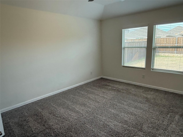 carpeted empty room with lofted ceiling