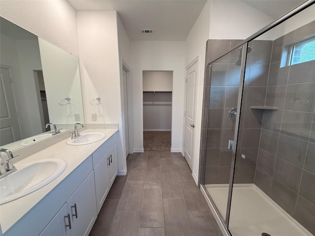 bathroom with vanity and a shower with door