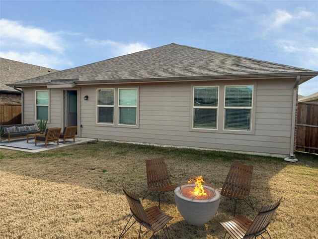 rear view of property featuring a yard, a patio area, and an outdoor fire pit