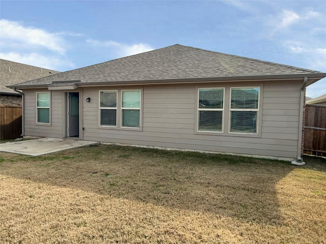 back of house with a patio and a lawn