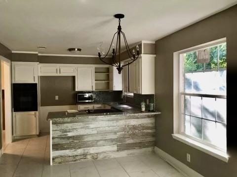 kitchen with hanging light fixtures, light tile patterned floors, kitchen peninsula, wall oven, and white cabinets