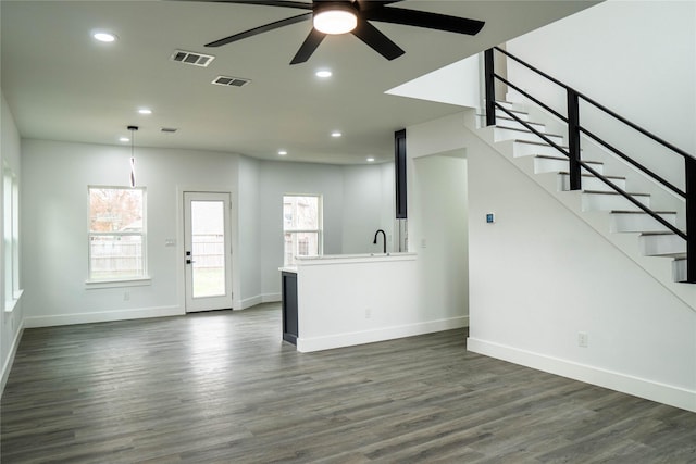 unfurnished living room featuring ceiling fan, dark hardwood / wood-style flooring, and sink