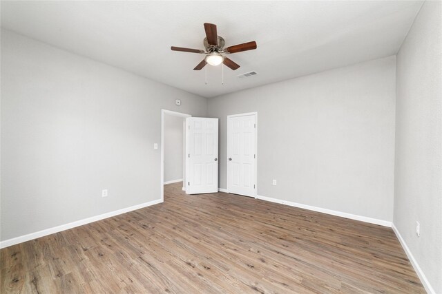 bathroom featuring hardwood / wood-style flooring, vanity, and tiled shower / bath combo