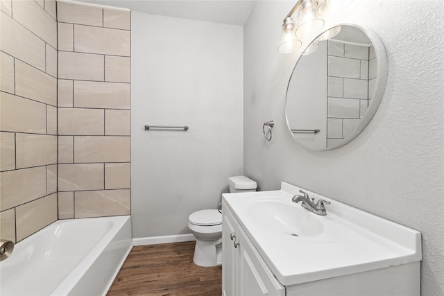 full bathroom with tiled shower / bath combo, vanity, hardwood / wood-style floors, and toilet