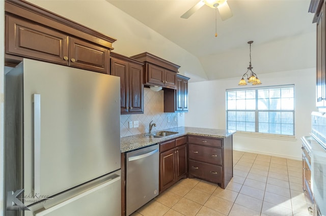 kitchen featuring sink, light stone counters, appliances with stainless steel finishes, kitchen peninsula, and decorative backsplash