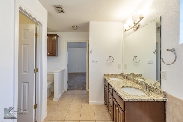 bathroom featuring vanity, tile patterned floors, and toilet