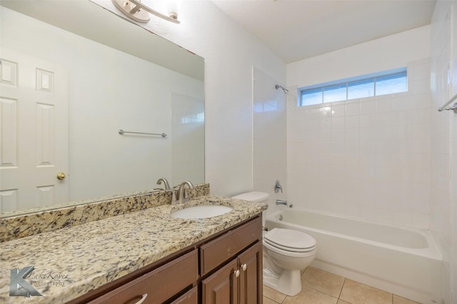 full bathroom with tiled shower / bath, vanity, tile patterned floors, and toilet