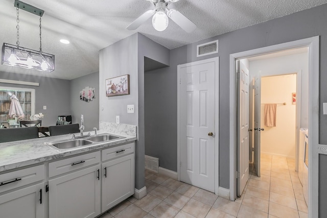 kitchen with pendant lighting, light tile patterned floors, a textured ceiling, and white cabinets