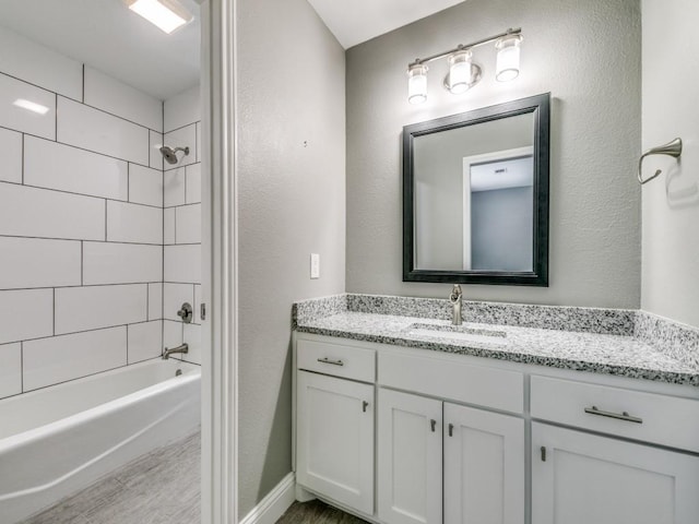 bathroom featuring vanity, hardwood / wood-style flooring, and tiled shower / bath