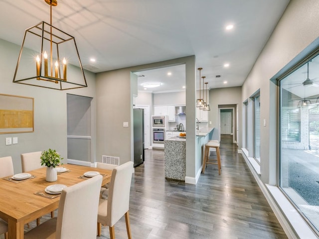 dining room with an inviting chandelier, dark hardwood / wood-style flooring, and sink