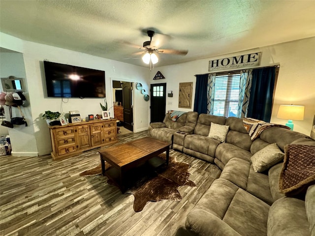 living room with wood-type flooring, ceiling fan, and a textured ceiling