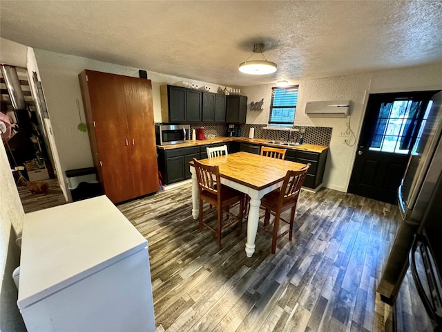 dining space with dark hardwood / wood-style floors, sink, and a textured ceiling