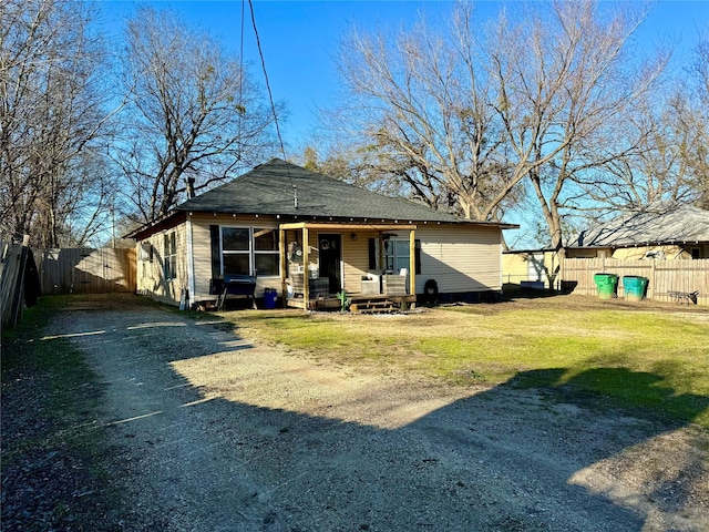 rear view of property featuring a lawn