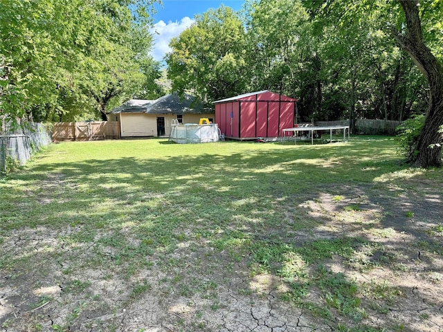 view of yard with a pool and a trampoline