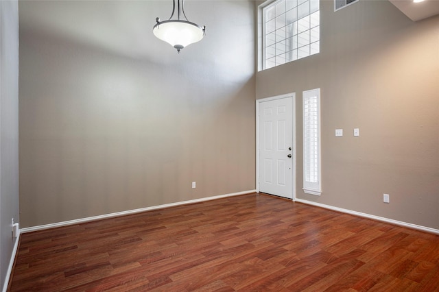 foyer featuring a high ceiling and dark hardwood / wood-style flooring