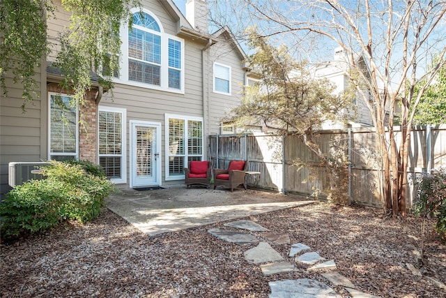 rear view of property featuring central AC unit and a patio