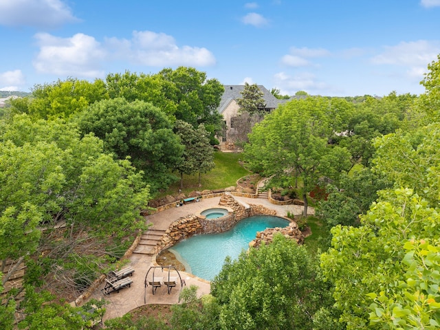 outdoor pool featuring an in-ground hot tub and a patio area