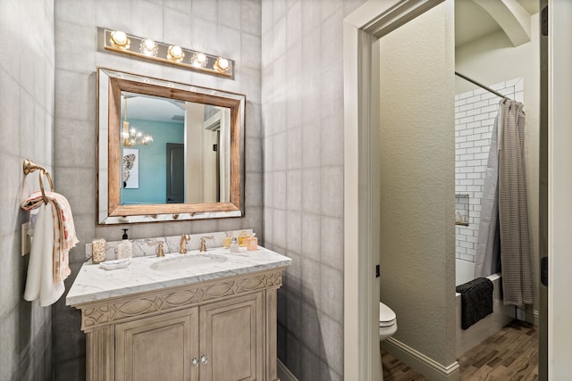 bathroom featuring wood finished floors, toilet, vanity, a shower with curtain, and a chandelier