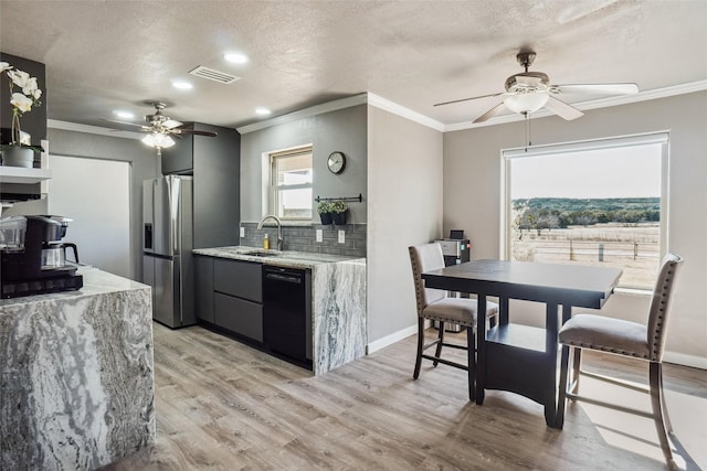 kitchen with tasteful backsplash, stainless steel fridge, black dishwasher, and light hardwood / wood-style floors