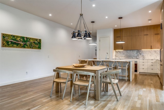 dining room with sink and light hardwood / wood-style flooring