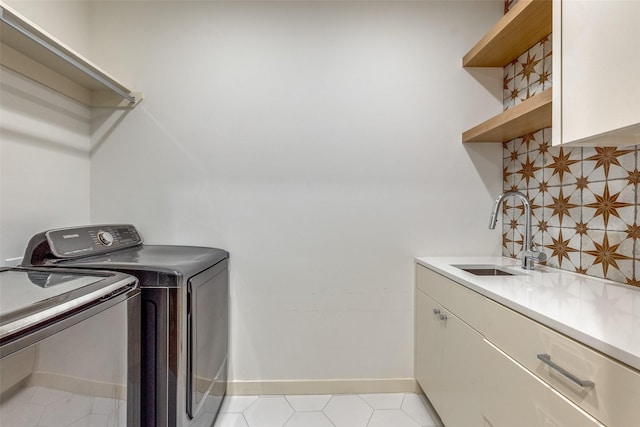 washroom with cabinets, sink, and washer and dryer