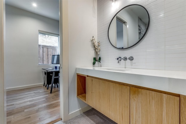 bathroom featuring vanity, hardwood / wood-style flooring, and tasteful backsplash