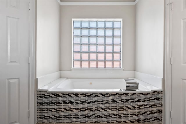 bathroom with ornamental molding and tiled bath