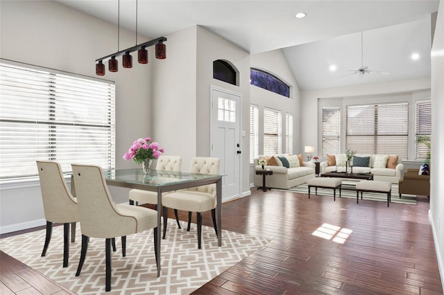dining room featuring a wealth of natural light, baseboards, wood-type flooring, and high vaulted ceiling