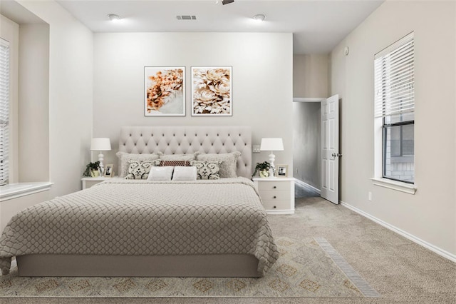 bedroom with light colored carpet, visible vents, and baseboards