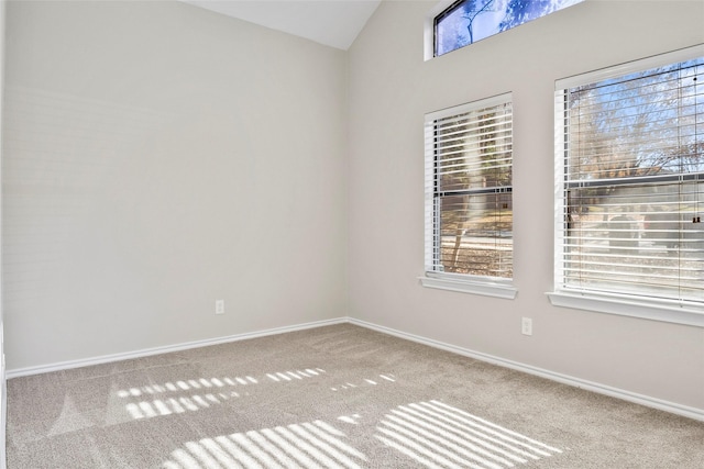 spare room with vaulted ceiling and carpet