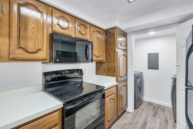 kitchen with separate washer and dryer, light hardwood / wood-style flooring, electric panel, and black appliances