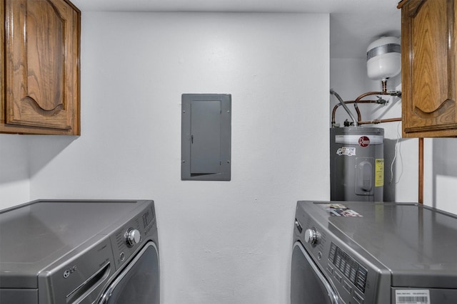 laundry area with water heater, washer and dryer, electric panel, and cabinets