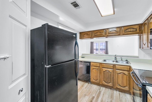 kitchen with sink, light hardwood / wood-style flooring, and black appliances