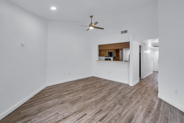 unfurnished living room with high vaulted ceiling, ceiling fan, and light hardwood / wood-style flooring