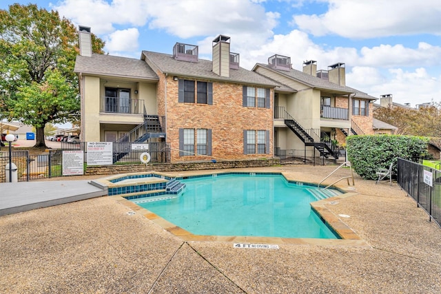 view of swimming pool with a patio area and a community hot tub