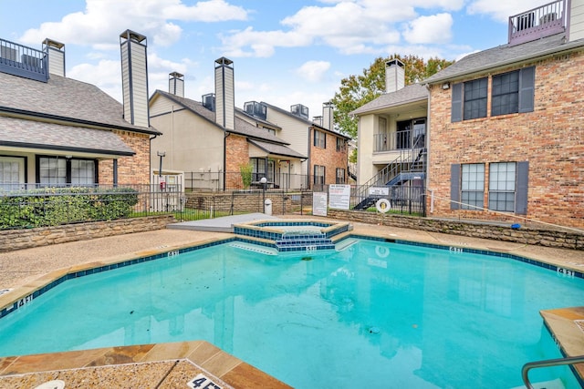 view of swimming pool with a community hot tub