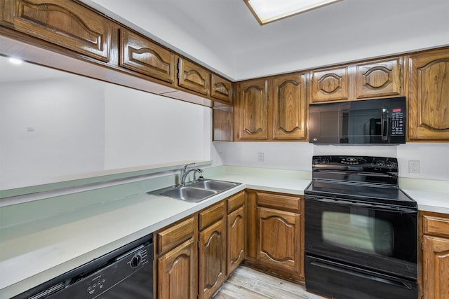 kitchen featuring sink, black appliances, and light wood-type flooring