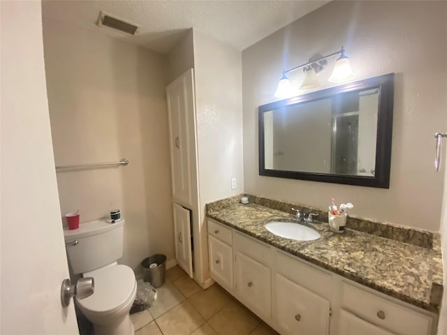 bathroom featuring vanity, tile patterned floors, a textured ceiling, and toilet