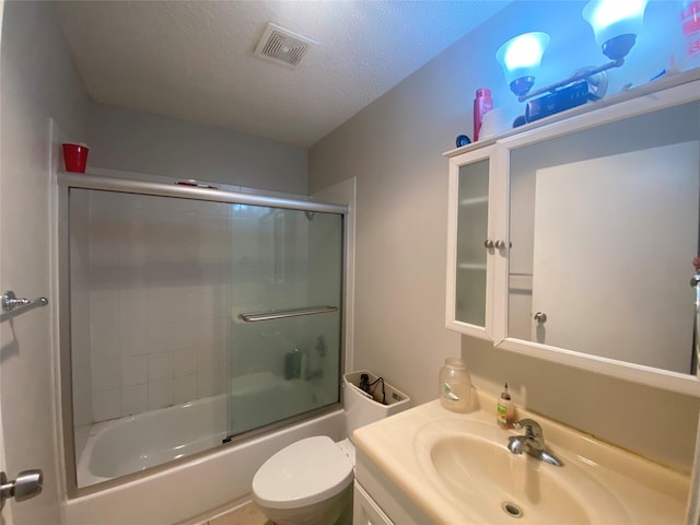 full bathroom with shower / bath combination with glass door, vanity, toilet, and a textured ceiling