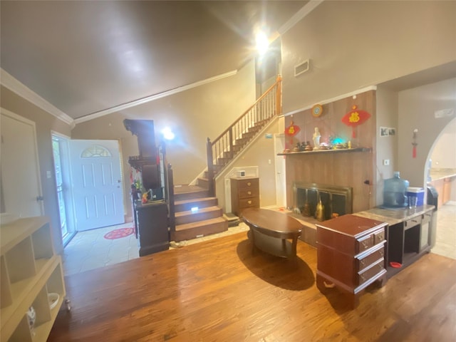 interior space featuring crown molding, wood-type flooring, and high vaulted ceiling